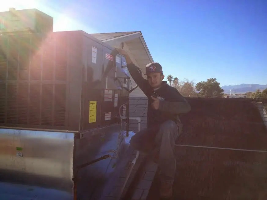 HVAC technician performing Boiler Repair on a rooftop unit in Edna